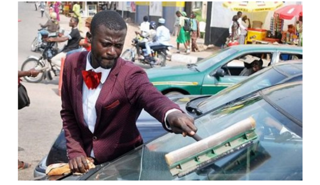 Man in suit spotted cleaning car windscreens
