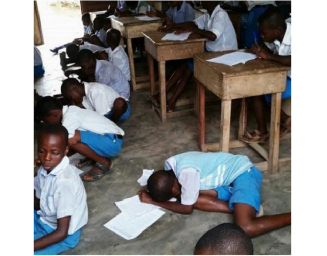 Students writing exams on bare floor